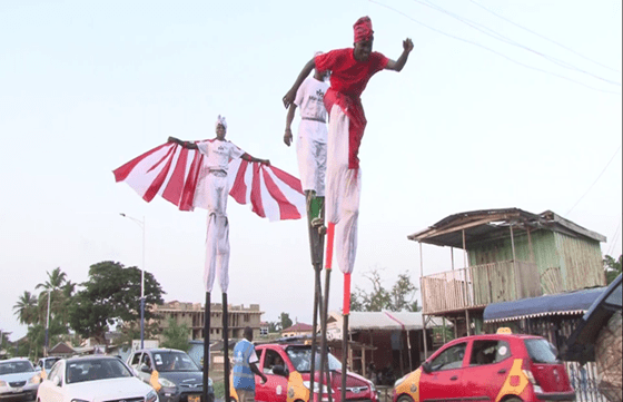 Stilt walkers exhibiting their skilled moves through traffic.
