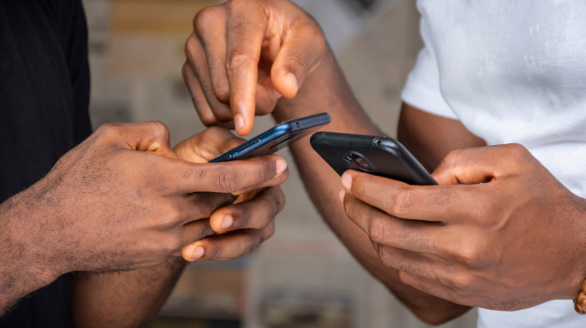 Two African men holding mobile phones